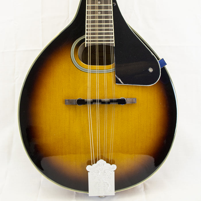 Kona KMA2 A-Style Oval Hole Mandolin

The Kona A style oval-hole mandolin offers a laminate spruce top with Lindenwood back and sides in a beautiful tobacco sunburst finish. It features a fully bound body and multi-ply top binding. It also features a mapl